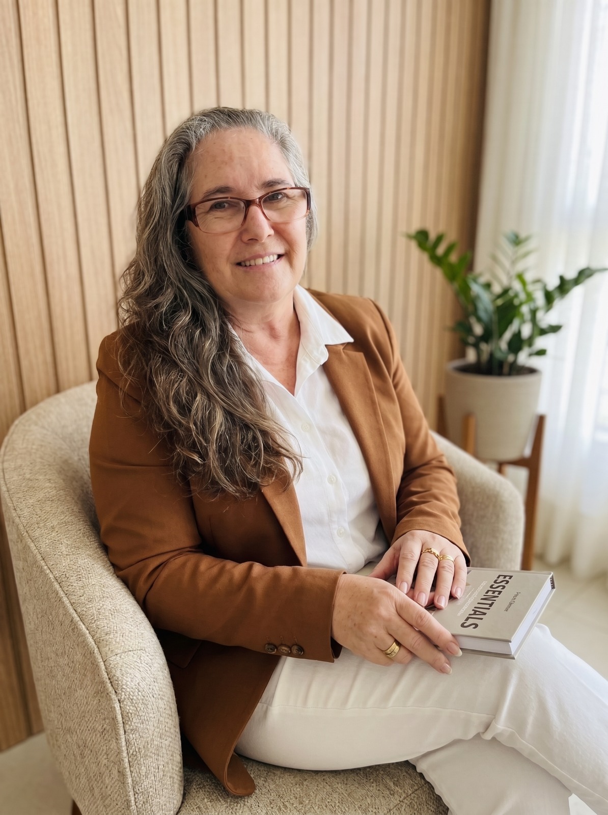 Giorgia Jaeger sentada em uma poltrona, segurando um caderno